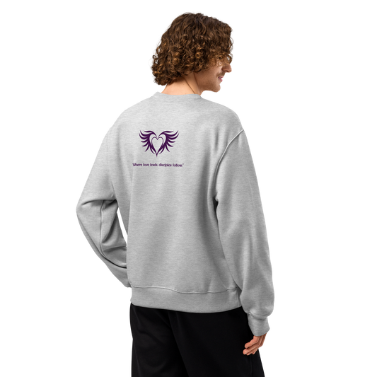 Person wearing a gray sweatshirt with a logo and text on the back, on a white background